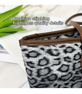 Détail de couture précise sur le cabas léopard noir et blanc avec bordure en cuir marron