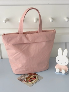 Detail of pink quilted tote bag with soft padded texture and sturdy matching handles