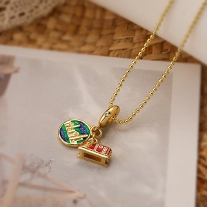 Gold plated bead chain necklace with green castle charm and red enamel tram pendant