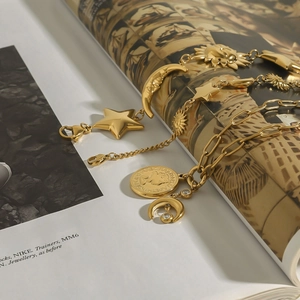 Detailed arrangement of 18k gold plated star and coin pendants on a fashion magazine