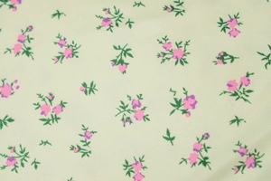 Close-up of light green floral fabric with small pink flowers and green leaves pattern
