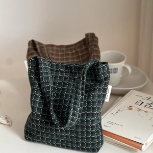 Detail of tweed checkered mini tote bag featuring woven texture and simple wish label