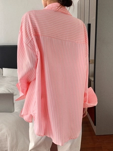 Back view of a loose-fit pink and white striped shirt for women with long sleeves