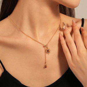 Detail of vintage sun flower necklace with brown tiger eye stone on gold chain