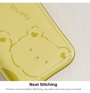 Detail of precise contrast stitching and cartoon bear print on yellow zip wallet
