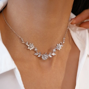 Gros plan du collier floral avec détails de fleurs et feuilles argentées sur un mannequin