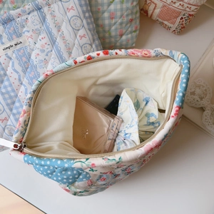 Macro view of floral quilted cotton makeup bag showing internal storage and metal zipper