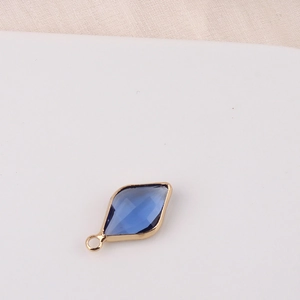 Detail of a gold-plated rhombus pendant with blue crystal for DIY jewelry making