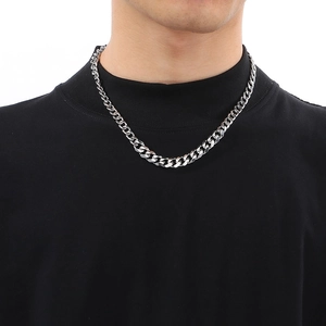 Close-up of a silver-tone men's Cuban link chain necklace on a male model's neck