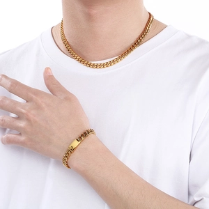 Detail of gold titanium steel Cuban chain set with polished rectangular plate clasp