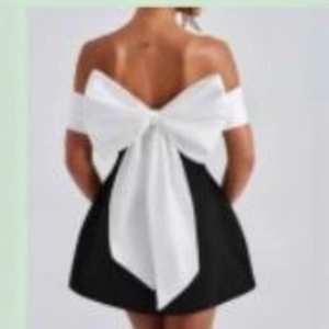 Robe de soirée chic noire à épaules dénudées avec un grand nœud blanc au dos