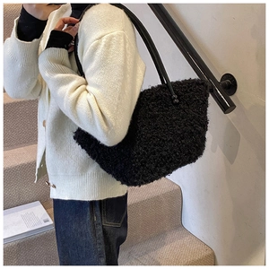 Gros plan du sac bandoulière en peluche noire montrant la texture et les poignées
