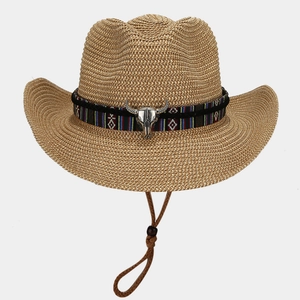 Vintage straw cowboy hat with ethnic band and silver bull head charm on white background