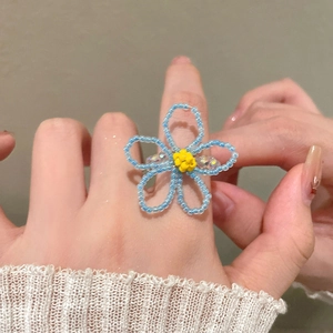 Détail de la bague fleurie faite main en perles bleues avec centre jaune brillant