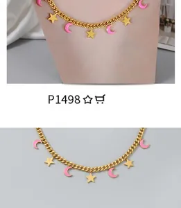 Detail of a gold necklace featuring pink crescent moons and bright yellow star pendants