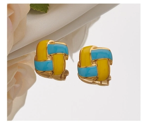 Close-up of square weave earrings featuring yellow and blue enamel on a gold base