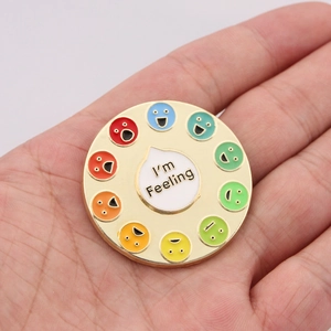 Macro detail of rainbow mood spinner enamel pin showing various colorful emoji expressions