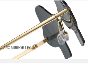 Detailed close-up of golden arc-shaped metal temples and silicone nose pads on sunglasses