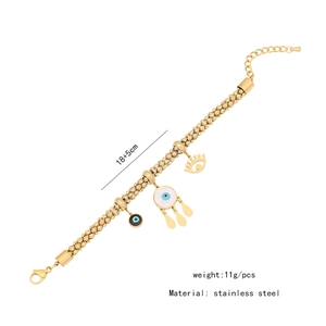Detail of gold stainless steel bracelet featuring evil eye, droplet and crown charms
