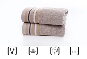 Close-up of soft beige cotton towels with striped edge showing absorbent loop texture