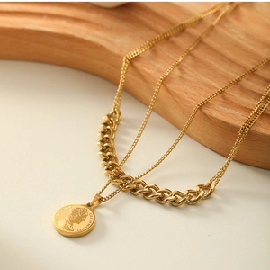 Close-up of layered 18k gold plated Cuban chain with Elizabeth II coin pendant charm