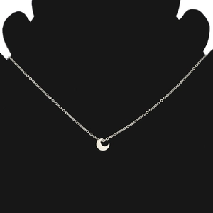 Detail of minimalist stainless steel crescent moon pendant necklace on black display stand
