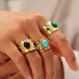 Detailed close-up of three gold vintage rings featuring turquoise, black, and green stones