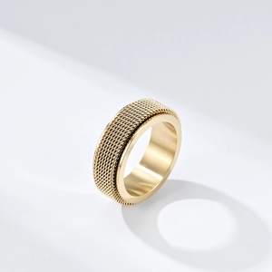 Golden stainless steel mesh spinner ring with a minimalist woven texture on white background