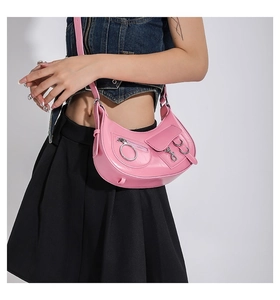 Détail du sac demi-lune rose montrant la texture du cuir poli et les boucles argentées