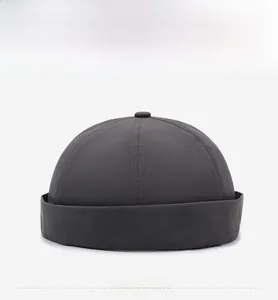Front view detail of a dark grey Miki Hat with multi-panel stitching and top button