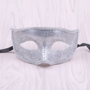 Detail of silver masquerade mask featuring glitter texture and black silk ribbons
