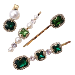 Detailed view of 4-piece hair clip set with green gemstones, pearls and crystals