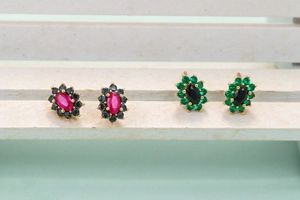 Detail of oval gemstone stud earrings with colorful zircon halo and gold plating