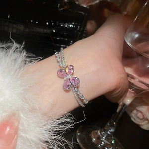 Macro view of double-layer silver bracelet with pink zircon flower and tiny pearls