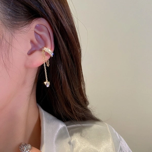 Détail du bijou d'oreille doré avec strass et pampilles à pendentifs en cœur