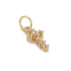 Macro detail of gold plated hip hop cross pendant with sparkling clear zircon stones