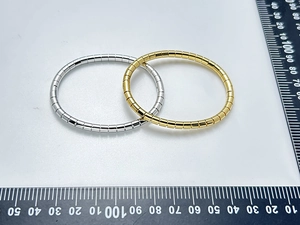 Detailed view of bamboo joint bracelets in gold and silver finish on measuring scale