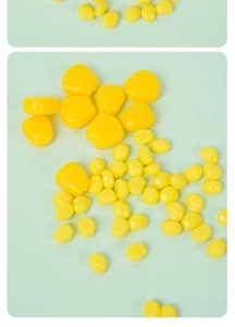 Macro view of realistic yellow resin corn kernels for DIY crafts and decor on mint background