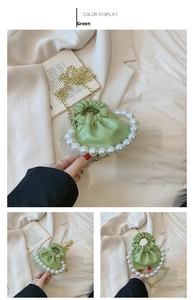 Detail of light green pleated mini bag with large pearls and gold chain strap