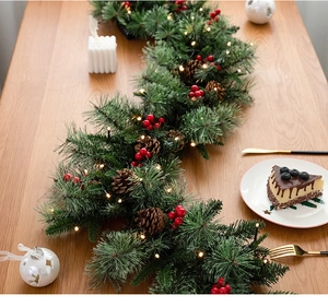 Detailed view of 135cm Christmas garland with pine needles, red berries and warm LED lights