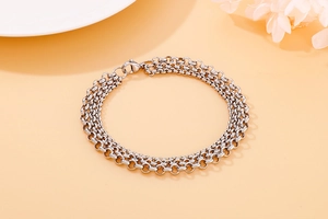 Detailed view of triple-layered silver steel chain bracelet with pearls and lobster clasp