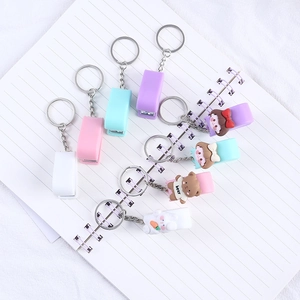 Cute cartoon mini stapler keychains in macaron colors on a notebook background