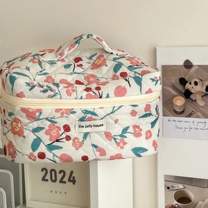 Detail of floral quilted makeup bag with vintage patterns and a sturdy metal zipper