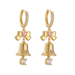 Close-up of golden Christmas bow earrings with pink heart zircon and bell charms