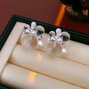Detailed close-up of pearl and zircon flower stud earrings in a luxury jewelry box