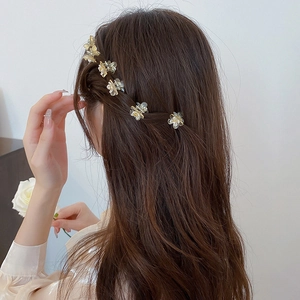 Close-up of translucent floral hair claws with pearl accents on a female model