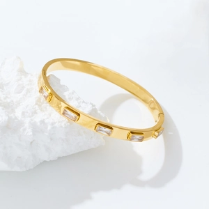 Λεπτομέρεια από επιχρυσωμένο βραχιόλι 18k από ανοξείδωτο ατσάλι με ζιργκόν σε λευκή πέτρα