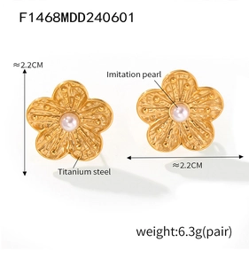 Detailed view of gold floral earring with pearl inlay showing size and titanium texture