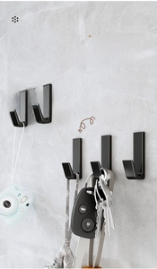 Modern matte black single hooks on marble wall showing heavy duty storage capacity