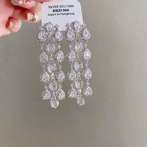 Detail of silver 925 tassel earrings with sparkling zircons and teardrop pendants